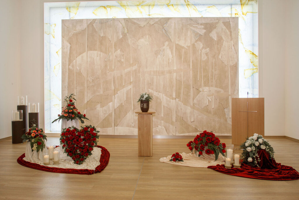 Kapelle mit Rednerpult und Blumenschmuck.