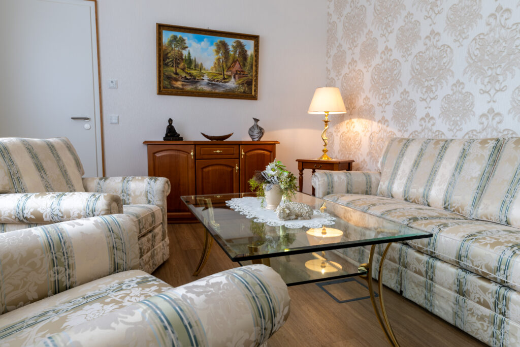 Büro Raum mit Sofas, Glastisch und Stehlampe.