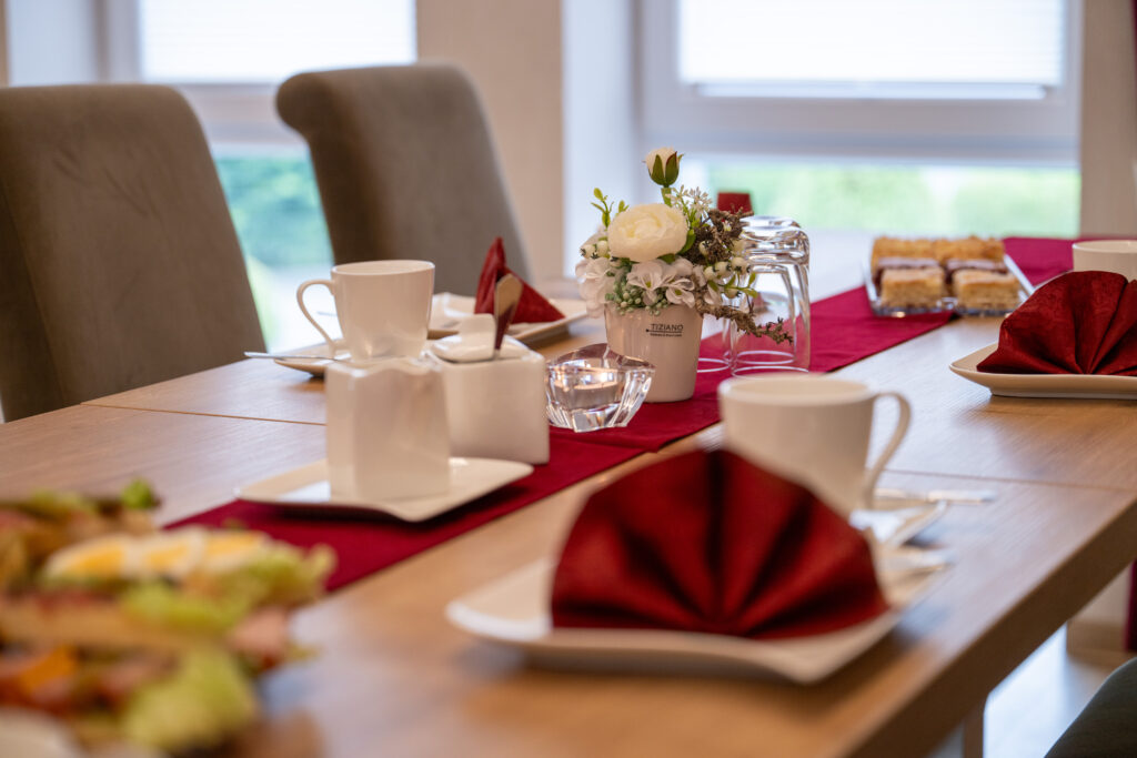 Gedeckter Tisch mit Kaffee, Gebäck und roten Servietten