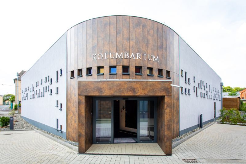 „Das Lindemann-Kolumbarium mit der Aufschrift ‚Kolumbarium‘ von außen, brauner Eingangsbereich mit Glastür