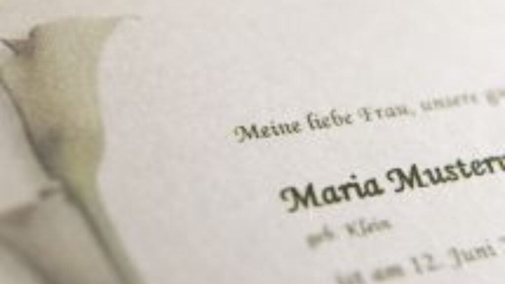 Ausschnitt einer Trauerkarte mit Name und Blütenmotiv – Ausdruck von Anteilnahme und Erinnerung.